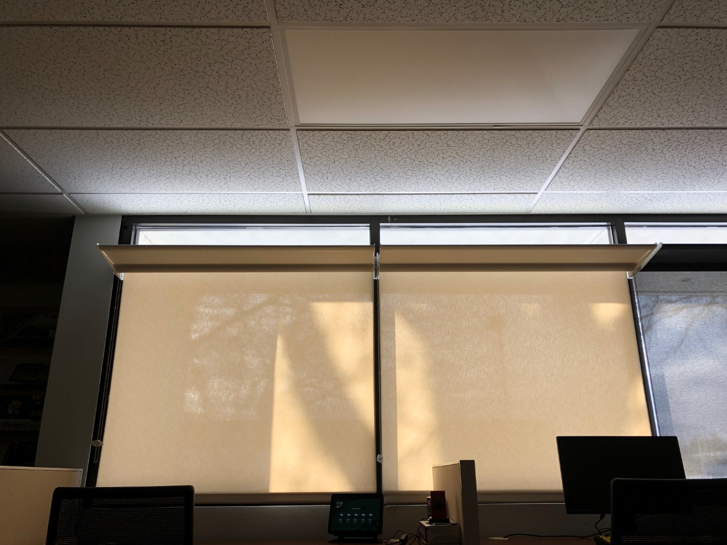 Office window with shades drawn and lightshelf open. Daylight spreads across the ceiling.